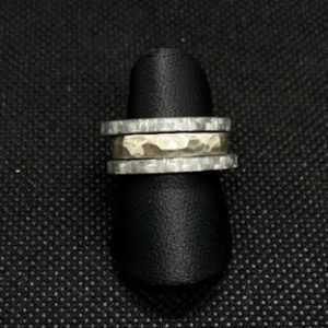 Drei Ringe auf einer Ring halterung mit dunklem Hintergrund. Dieses Bild dient zur Produktansicht