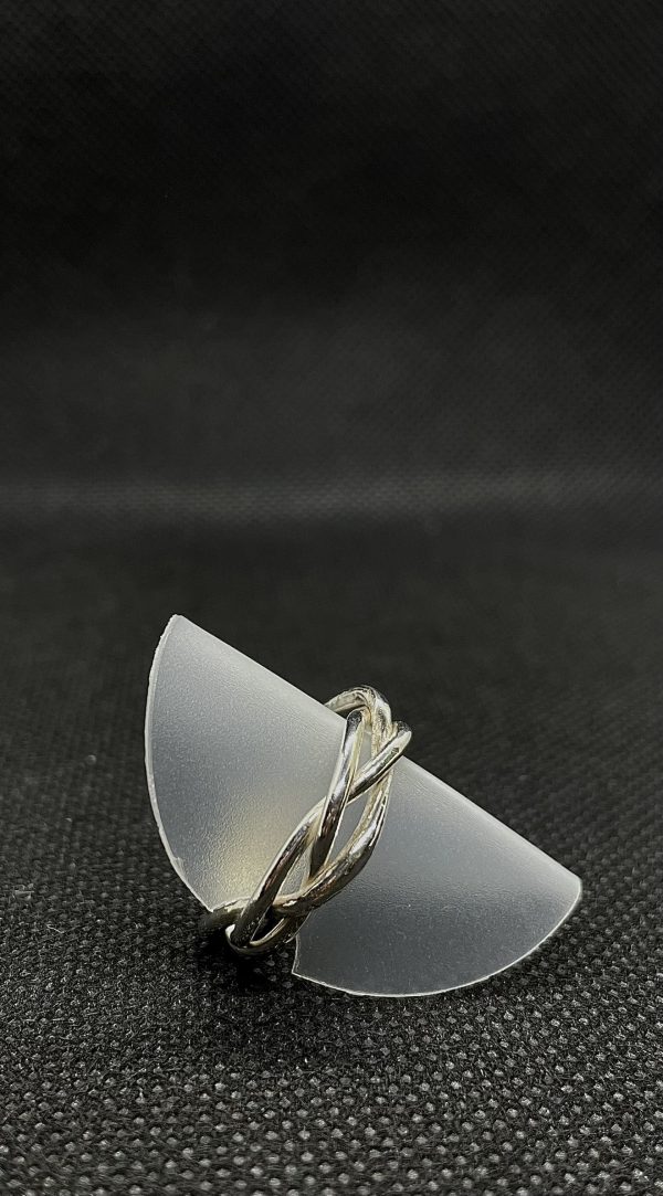 Geflochtener Ring aus 925/- Silber. Der Ring sitzt auf einer Ringhalterung auf dunklem Untergrund. Das Bild dient der als Produktansicht