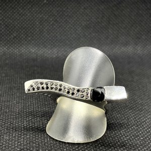 Ring aus 925/- Silber, besetzt mit schwarzen Diamanten in zwei verschiedenen Größen. Der Ring ist auf dunklem Untergrund und dient der Produktansicht.