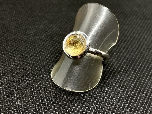 Ring aus 925/- Silber mit einer Citrin-kugel facettiert. Der Ring ist auf einer Ring Halterung und dient der Produktansicht.