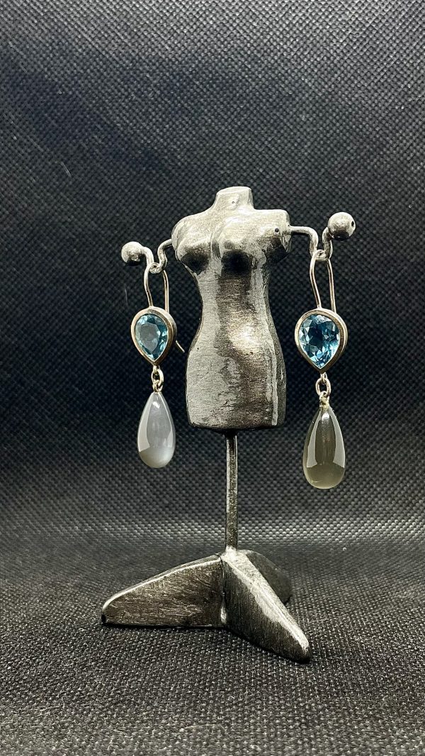 Topas Ohrhänger aus 925/- Silber auf einer kleinen, weiblich geformten Schmuckhalterung und dunklem Hintergrund. Das Bild dient der Produktansicht.